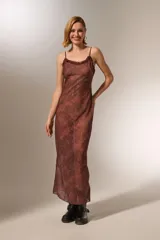 Vestido midi de poliéster con estampado animal print, breteles finos y volados en el escote. Corte al cuerpo y cuello redondo.