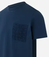 Remera azul marino de algodón, con cuello redondo y manga corta. Presenta un bolsillo delantero con detalles bordados.