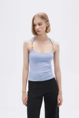 Musculosa celeste de punto canale con cuello recto y tirantes anchos decorados con cuentas de madera.