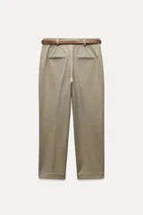 Pantalón de vestir color beige, de tiro alto y corte recto. Incluye cinturón marrón con hebilla metálica. Presenta bolsillos laterales y falsos bolsillos traseros de doble vivo. Cierre frontal con cremallera, botón interior y gancho oculto.