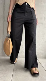 Pantalón negro de lino, de corte recto, con pinzas en la cintura y aberturas laterales en el ruedo.