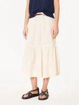 Pollera midi color crema, confeccionada en poplín liviano, con cintura elastizada, jareta con cordón, bolsillos tipo plaque con fuelle y recorte con volado fruncido.