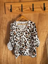 Blusón de seda con estampado animal print, corte amplio y mangas 3/4 ajustables.