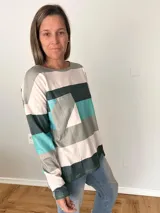 Remera de manga larga con diseño de rayas anchas en tonos fucsia, gris y crudo. Corte recto y cómodo con bolsillo delantero.