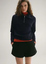 Sweater azul marino de punto fino con cuello alto con cremallera, manga larga y corte recto.