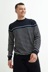 Sweater de punto a rayas horizontales blancas sobre fondo azul marino, con una línea horizontal verde en la parte superior. Cuello redondo, puños y bajo acanalados.