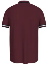Chomba Tommy Hilfiger color borgoña de corte regular, confeccionada en algodón orgánico y elastano. Presenta cuello tipo polo con cartera de dos botones, detalles distintivos de la marca y logo bordado en el pecho.