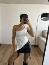Top blanco de lycra, con un solo hombro y corte irregular en la parte inferior.