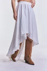 Pollera blanca de corte irregular, más corta en el frente y más larga en la parte trasera, con cintura elastizada.