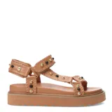 Sandalias bajas color tostado, con plataforma y tiras de cuero sintético con tachas doradas y negras.