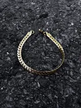 Conjunto de collar y pulsera dorados con eslabones de diseño intrincado.