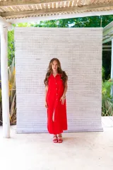 Camisola roja tipo vestido camisero, de corte midi, con cuello camisero, abotonada al frente y con abertura en el ruedo.