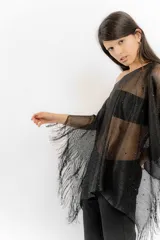 Poncho tejido color cobre con apliques de piedras y flecos.