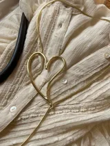 Collar dorado con cadena fina y dije en forma de corazón abierto.