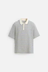 Polo de hombre con corte relaxed fit, cuello solapa con cierre frontal de botonadura y manga corta. Diseño a rayas horizontales en color crema y azul marino.
