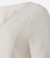 Vestido t-shirt corto de viscolino color crudo, con escote en V y manga corta. Presenta un estampado de follaje en tonos verdes y rosados en el bajo.