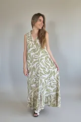 Vestido largo camisero sin mangas, con estampado de hojas en verde y blanco, cuello camisero y cierre frontal con botones.