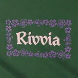 Remera de manga corta color verde oscuro con cuello redondo y un pequeño estampado frontal que dice "Rivvia" enmarcado por flores moradas.
