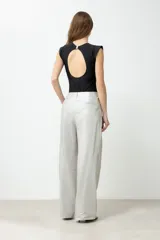 Pantalón de tiro alto, color plateado metalizado, con pliegues frontales y corte ancho y largo.