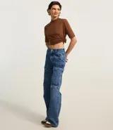 Remera femenina de algodón color marrón, con cuello alto en punto roma y mangas cortas con dobladillo.