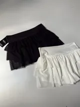 Short pollera con volados de tul en capas, color negro y blanco.