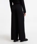Pantalón de vestir negro de corte recto, con bolsillos laterales y traseros. Se ajusta a la cintura con cierre de botón y cremallera.