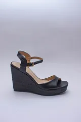 Sandalias de plataforma color lila con capellada de cuero y taco corrido cubierto de rafia.