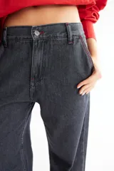 Pantalón de jean azul oscuro, de corte baggy y tiro bajo, con pespuntes a contratono color verde lima y logo bordado en el bolsillo trasero. Confeccionado en denim 100% algodón.