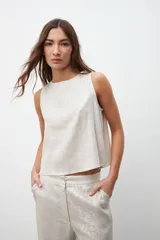 Musculosa color crudo con textura laminada, de corte recto y sin mangas.