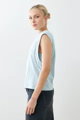 Musculosa verde agua con cuello redondo y sisas con detalle de vainillas.