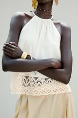 Top blanco de cuello halter con detalle de crochet en el ruedo.