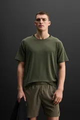 Camiseta deportiva color verde oliva de tejido ligero y elástico, con cuello redondo, manga corta y logo estampado en el bajo. Zara Athleticz.