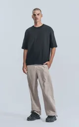 Remera negra de corte crop y calce oversize, con hombros caídos y cuello redondo.