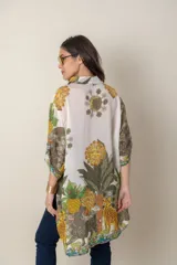 Camisa italiana de viscosa estampada con diseño abstracto en tonos azul, amarillo y verde sobre fondo natural, de corte irregular y mangas 3/4.
