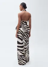 Pantalón de mujer con estampado de cebra en tonos blanco, negro y dorado. Diseño wide leg, tiro medio y detalle de pinzas. Cierre delantero con botón, gancho y cremallera ocultos.