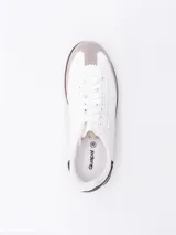 Zapatillas urbanas negras con cordones blancos y suela marrón.