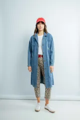 Tapado largo de jeans azul con bordado en la espalda, cuello camisero, bolsillos laterales y cierre frontal con botones.