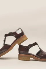 Zapato guillermina de cuero vacuno charol color negro, con suela de goma color marrón.