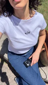 Remera blanca estilo baby tee de algodón con estampado de un zapato Mary Jane.