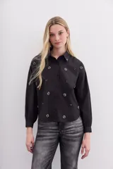 Camisa holgada de algodón color negro, con bordados de piedras en el frente y la espalda, cuello camisero y mangas largas.