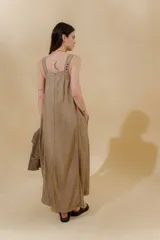 Vestido largo de jean celeste con breteles anchos, corte recto, abertura lateral y bolsillo plaqué en el pecho.
