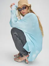 Buzo de algodón con efecto tie-dye en tonos celeste y blanco, de corte holgado y largo por debajo de la cintura, con puños acanalados.