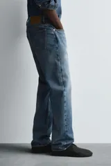 Pantalón de jean celeste de corte recto, con cinco bolsillos y cierre frontal con botones.