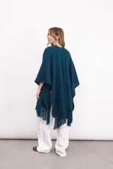 Ruana tejida en lana merino color amarillo pastel, con terminación de flecos.