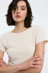 Top blanco de textura arrugada, con cuello redondo y mangas cortas.