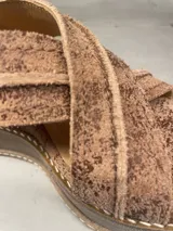 Sandalias de cuero color marrón con plataforma y tiras cruzadas.