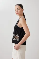 Top negro sin mangas con bordado blanco en el frente y contorno.