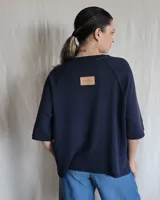 Sweater color beige de tejido de punto con mangas cortas y cuello redondo.