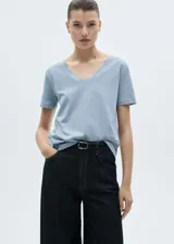 Camiseta celeste de algodón orgánico y reciclado, con cuello pico y mangas cortas.