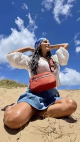 Bandolera color rosa viejo con detalles en cuero marrón claro, múltiples cremalleras metálicas y herrajes plateados. Incluye correa ancha ajustable con el logo de la marca.